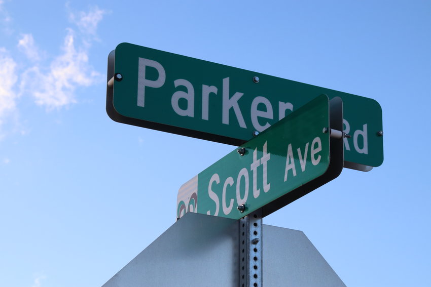 Road signs mark the intersection of state Highway 83 (noted by the sign as Parker Road) and Scott Avenue, where a proposed apartment complex may be built.